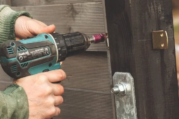 Person befestigt Holzlatten mit Akkuschrauber